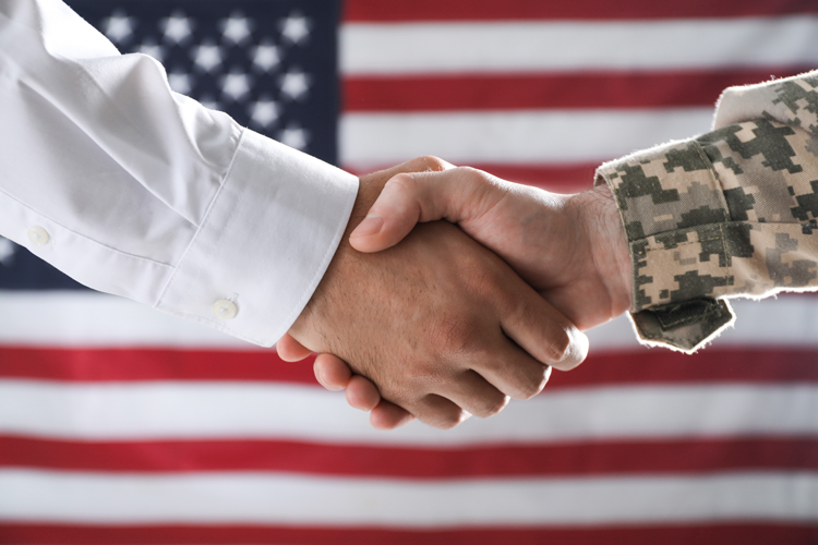 Veterans handshake with American flag in the back veteran services
