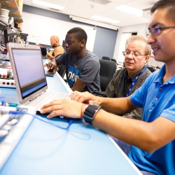 student working in computer lab with professor