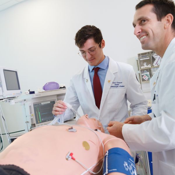 two student doctors working on a moc patient in lab