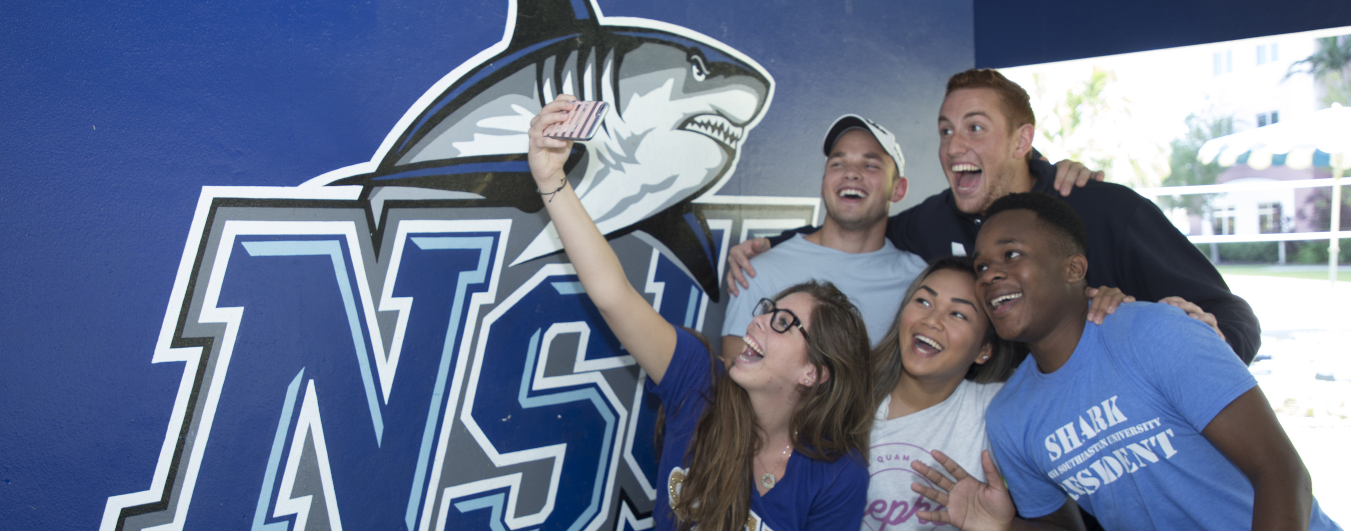 students taking a selfie with nsu shark 