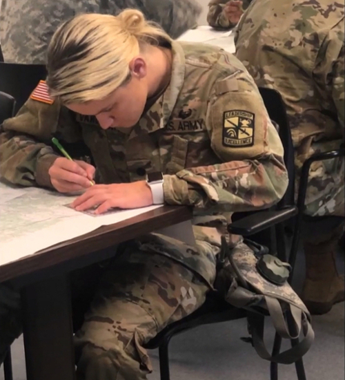 rotc female student writing at desk