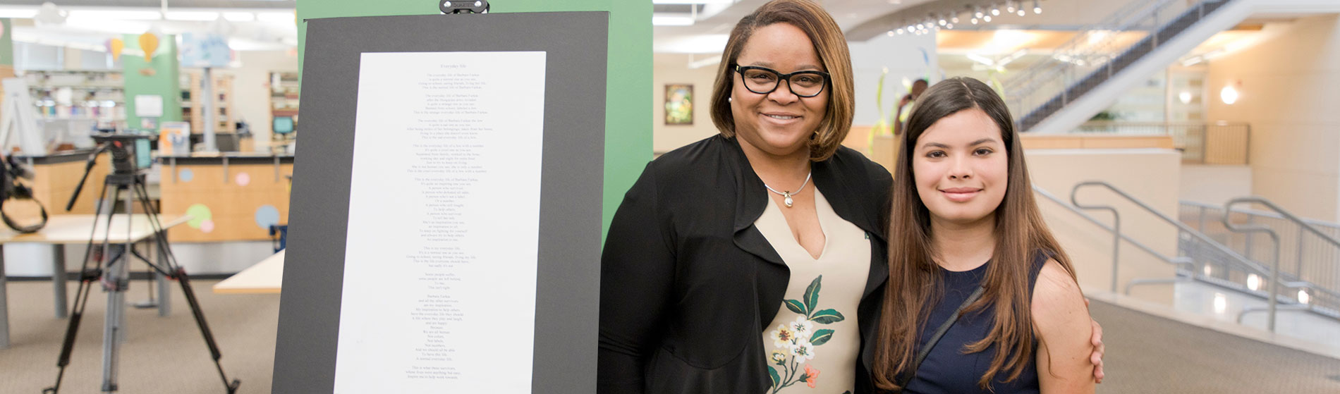 girl with teacher displaying her essay