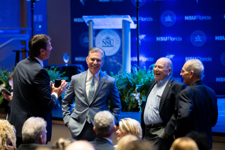 Audience members talking near the stage setup
