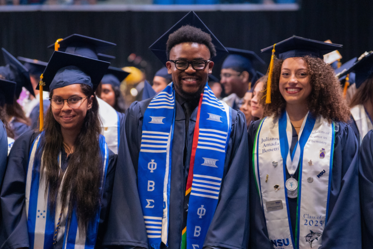 three-graduates-posing-together-during-ceremony