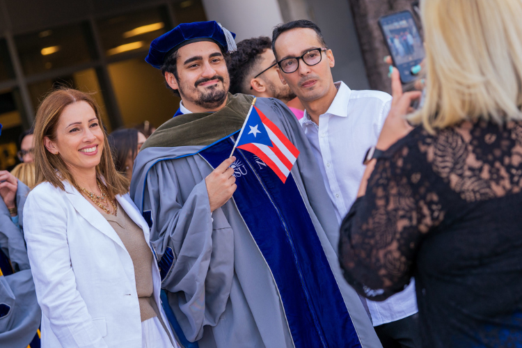 graduate-holding-flag-posing-with-family
