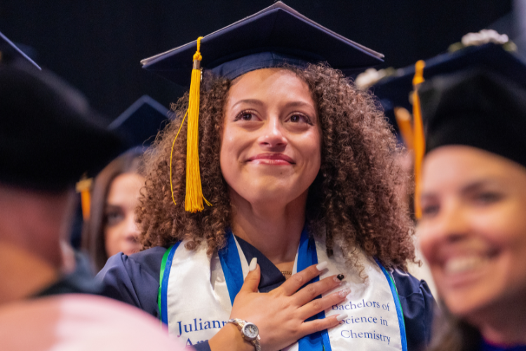 graduate-smiling-with-hand-on-chest