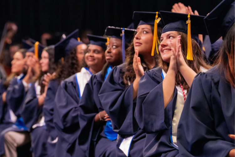 row-of-graduates-clapping-during-ceremony