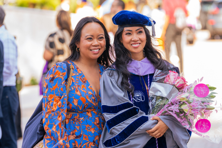 graduate-holding-flowers-posing-with-family